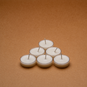 Six white tealight candles arranged in a triangle on a brown background